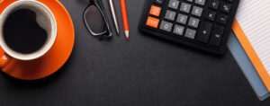 Office desk with coffee, notepad and supplies. Top view with space for your text